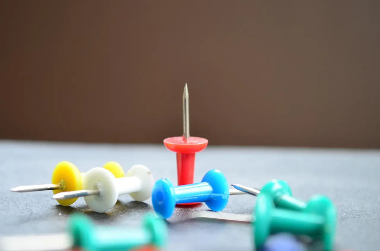 Colored push pins on a flat surface