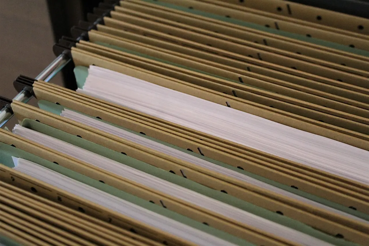 An open filing cabinet drawer with folders